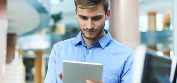 Ein junger Mitarbeiter arbeitet am Tablet