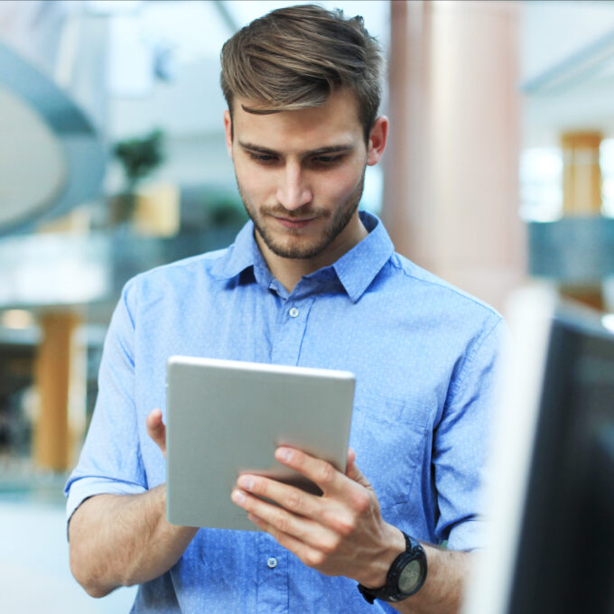 Ein junger Mitarbeiter arbeitet am Tablet