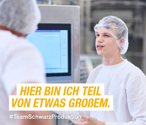 Azubi mit Haarnetz vor einem Bildschirm