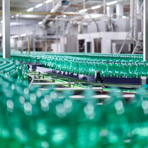 türkis-grüne Wasserflaschen auf einem Fließband